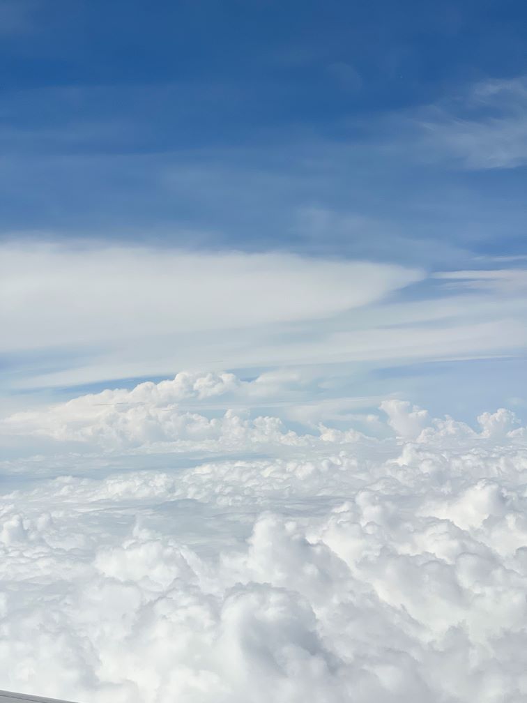 Large, white clouds occupying half of the photo with a blue sky occupying the upper half.