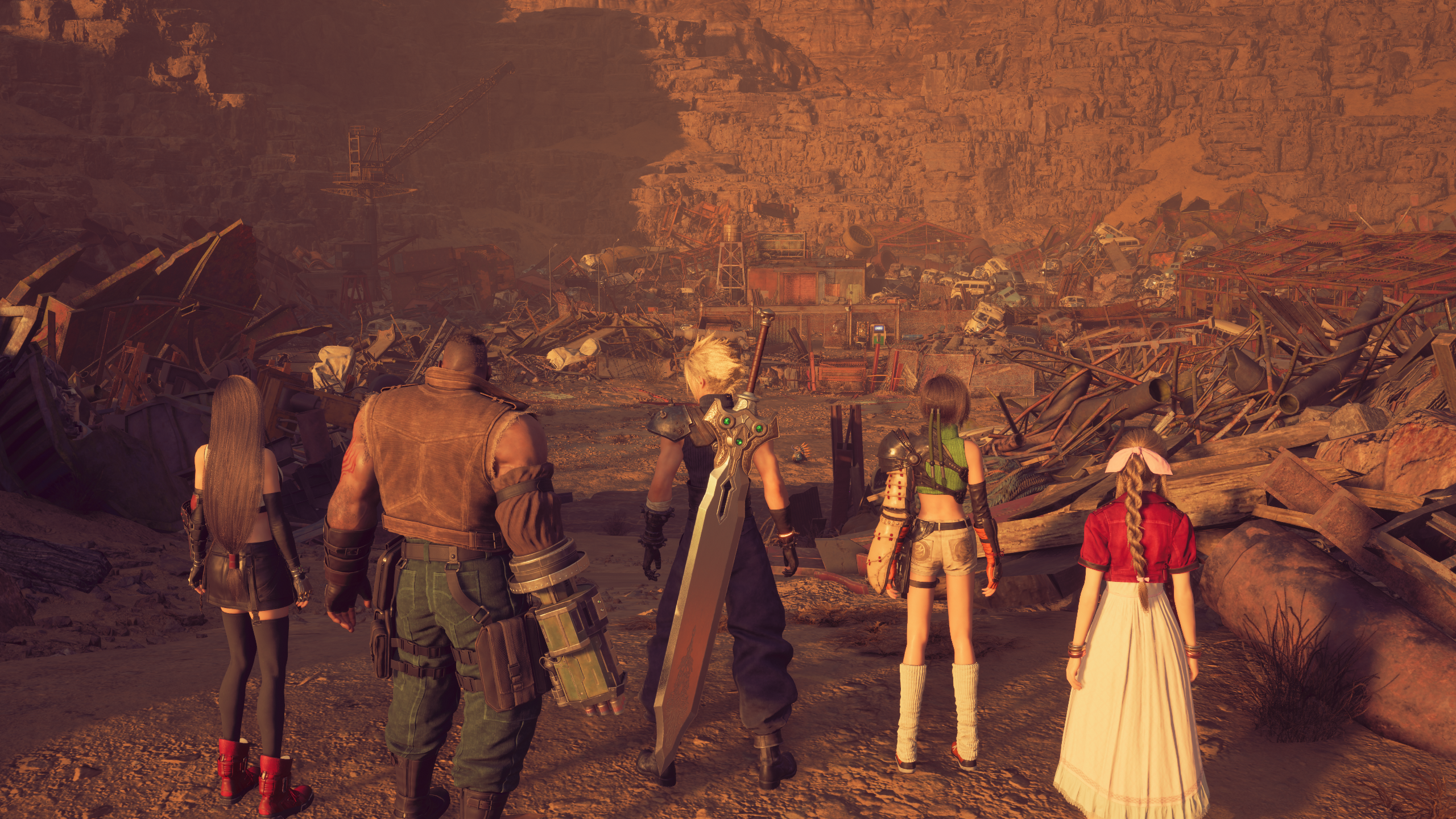 A team of five characters standing in the foreground with the background of a scrapyard looming behind.